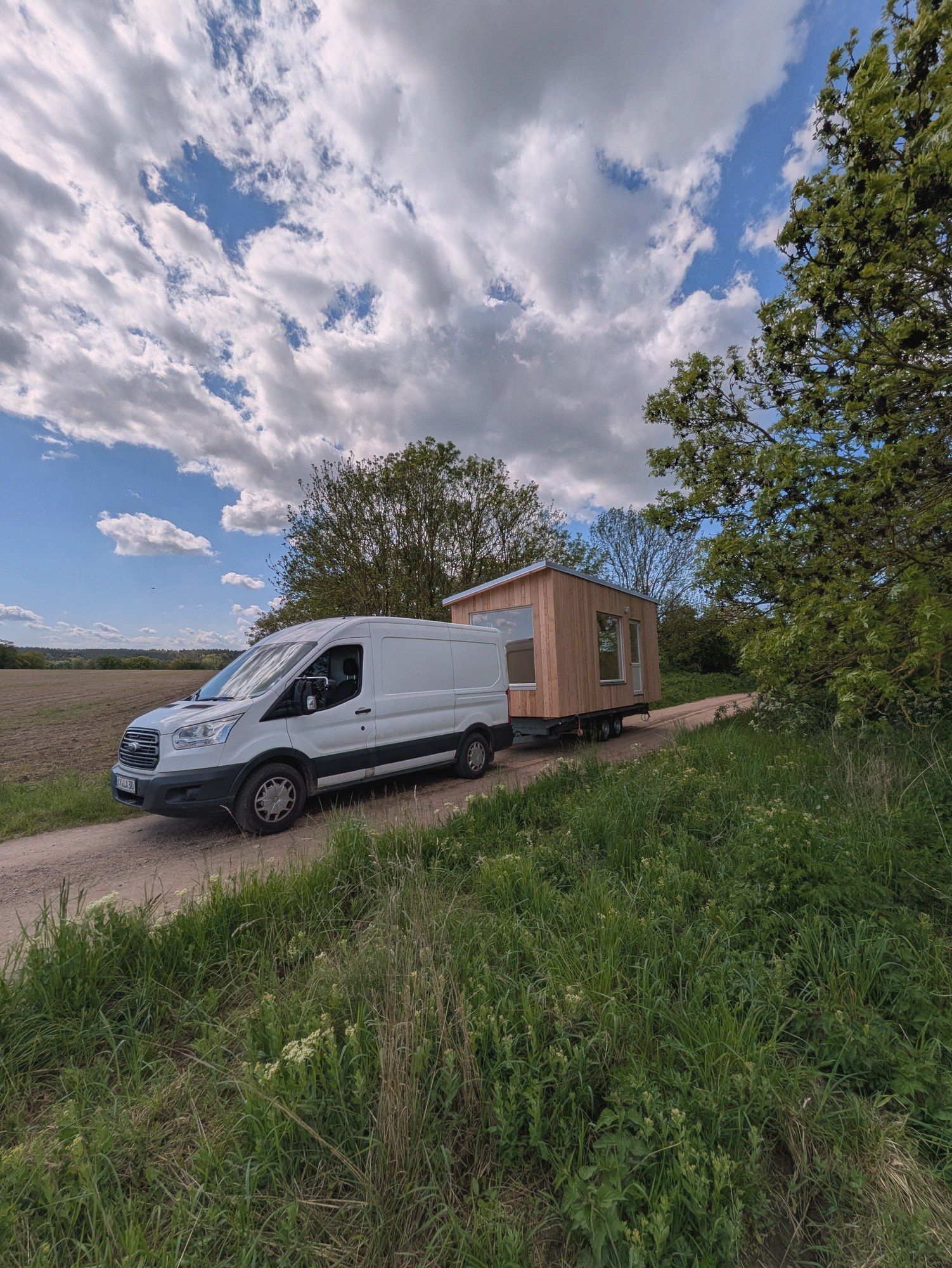 Transporter mit dem LandAnker am Anhänger auf einem Feldweg am Ackerrand