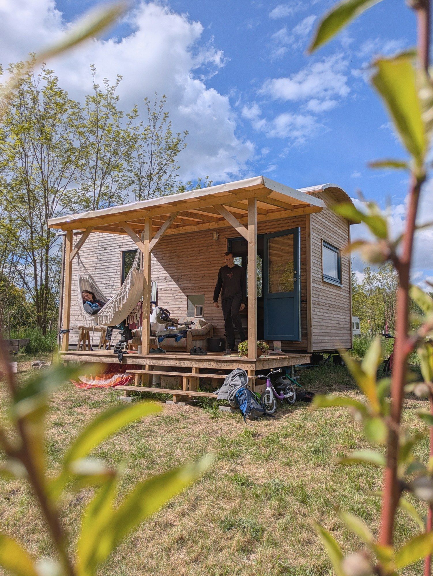 LandAnker mit Vordach, darunter eine Hängematte, davor ein Kinderfahrrad